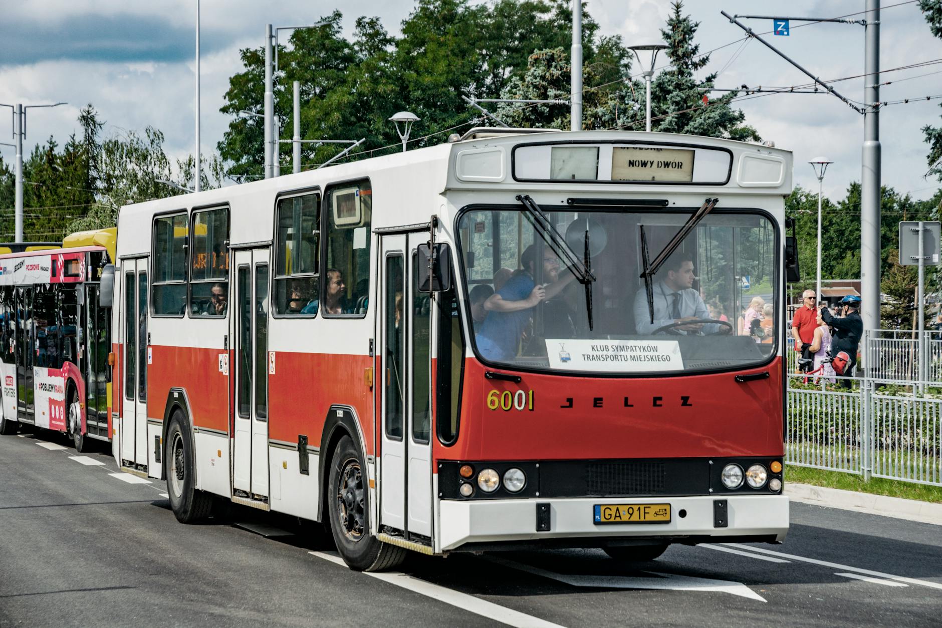 Historyczny autobus Solaris na tle nowoczesnego Wrocławia, obok znak drogowy informujący o utrudnieniach na autostradzie A4