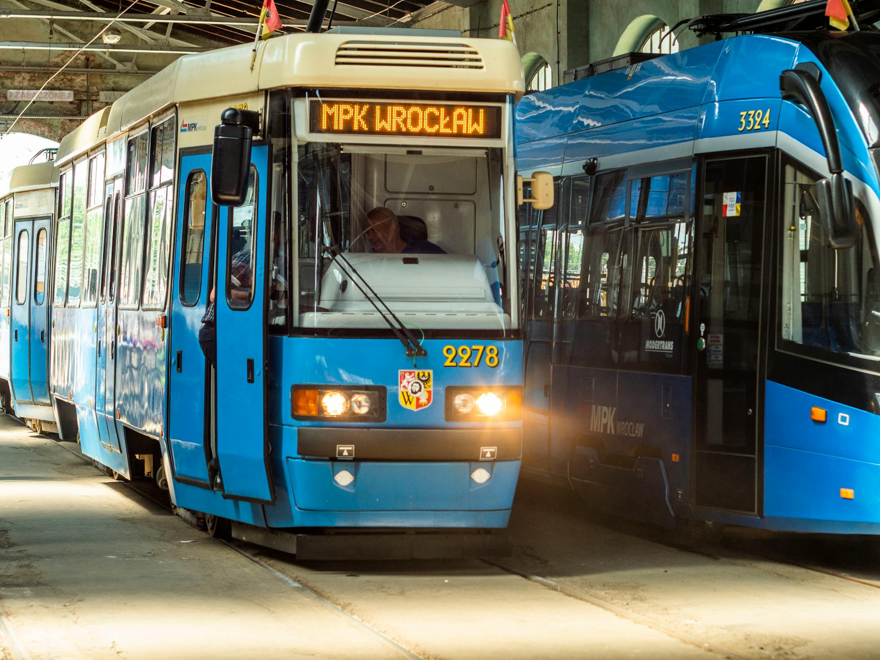 Uczestnicy Dnia Otwartego MPK Wrocław zwiedzają zajezdnię Borek, oglądając autobusy i tramwaje.